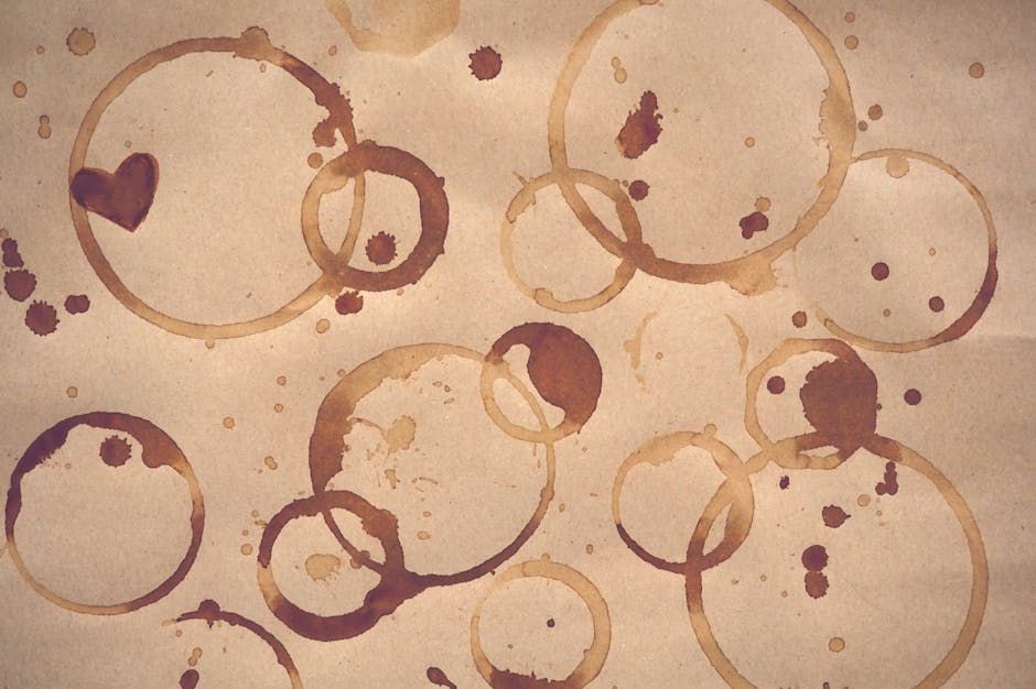 Intricate abstract design featuring coffee rings and a heart shape on paper.